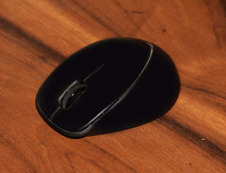 A Wireless mouse on a wooden tableの写真素材
