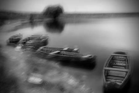 Blurry long exposure image of storm at Danube river with fishing boats の写真素材