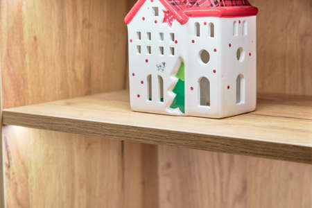Bookshelf with a toy house on itの写真素材