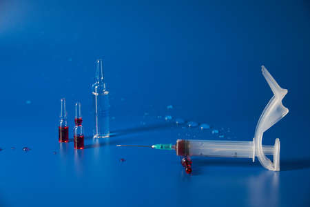 Syringe and medicines lie on blue backgroundの写真素材