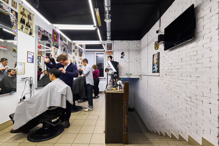 An atmospheric barbershop interior with working employeesの写真素材
