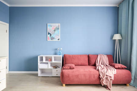 Stylish studio apartment interior with comfortable beige sofaの写真素材