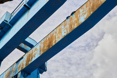 Rusty blue metal construction against gray skyの写真素材