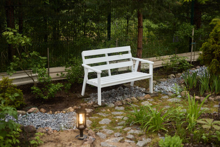 A Serene and Beautiful Garden Bench Enveloped by Nature That Invites Relaxation and Peacefulnessの写真素材
