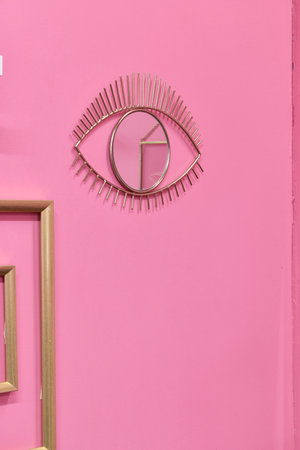 Stylish Eye Wall Art Featuring a Beautiful Design on a Soft Pink Background Wallの写真素材