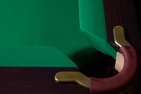 A CloseUp View of a Corner of a Billiards Pool Table Featuring Green Felt and Elegant Brass Detailsの写真素材
