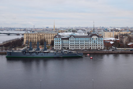 A historic ship now docks by the river in a vibrant urban setting, adding charm