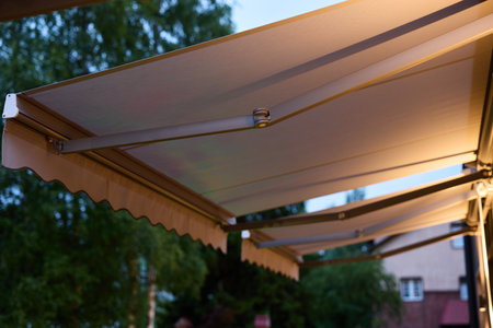 An Elegant Outdoor Awning with Warm Lighting that Creates Ambiance at Dusk During Evening Hoursの写真素材