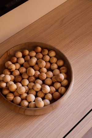 An Elegant Wooden Bowl That Is Beautifully Filled with Natural Decorative Orbs Inside