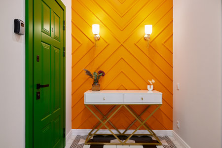 This is a vibrant entryway that features a colorful accent wall along with modern decor elementsの写真素材
