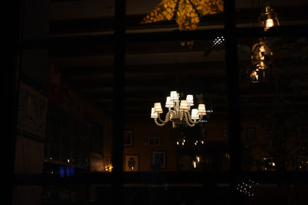 An Elegant Chandelier Reflection in the Dimly Lit and Cozy Restaurant Interior Atmosphereの写真素材