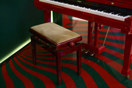 Beautifully Elegant Red Piano Paired with a Matching Bench in Unique and Artistic Interior Setupの写真素材