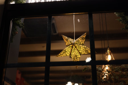 A shining star decoration beautifully enhances the cozy cafe setting and inviting atmosphereの写真素材