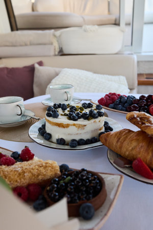 An Elegant Breakfast Spread featuring exquisite Desserts along with Fresh, Delightful Berriesの写真素材