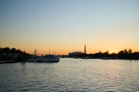 A Serene Sunset Over a River with a Beautiful and Captivating Cityscape in Clear Viewの写真素材