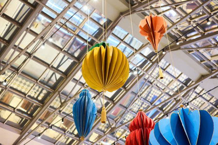 Colorful and Vibrant Hanging Decorations Suspended Beneath a Beautiful Glass Ceilingの写真素材