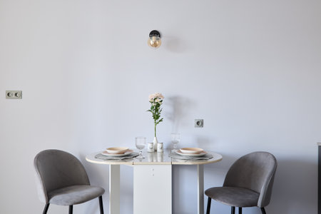 A modern minimalist dining table set featuring a charming floral centerpiece for decor