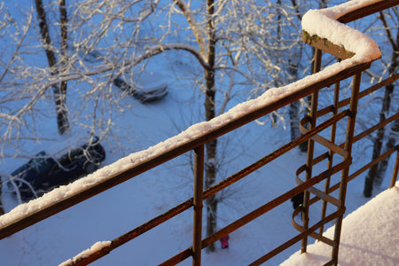 A beautiful, peaceful winter scene showcasing a snowcovered balcony and surrounding treesの写真素材