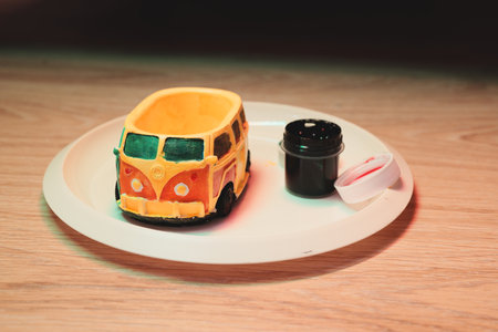 A Colorful Vintage Car Model is placed on a decorative Plate, accompanied by a Containerの写真素材