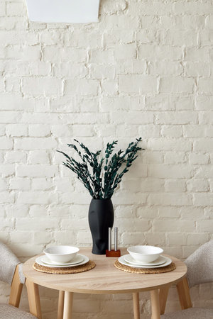 An Elegant Minimalist Dining Setup Featuring a Beautiful Vase and Carefully Arranged Plates