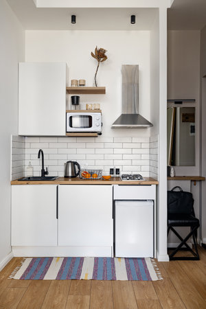 Trendy Modern Kitchen Design with Elegant White Cabinets and Charming Wooden Accentsの写真素材