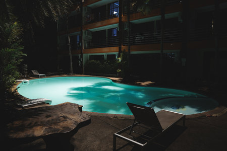 Experience a serene nighttime atmosphere by the poolside at a cozy and inviting resortの写真素材
