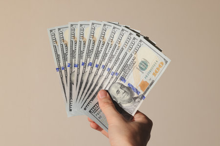 Hand Grasping a Stack of Money A Concept Representing Financial Wealth and Abundanceの写真素材