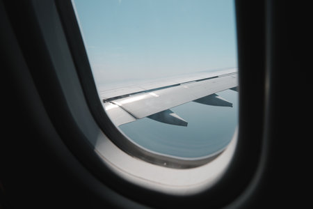 Enjoy an Aerial View Through the Airplane Window Featuring the Wing and the Beautiful Sky