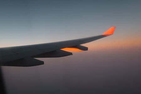 A Beautiful and Scenic View from an Airplane Wing During a Majestic Sunset in the Skyの写真素材
