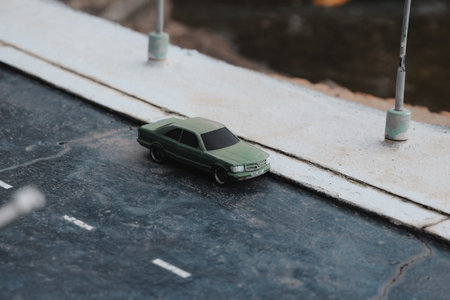 Miniature Green Car is positioned on a Street Model showcasing urban life in detailの写真素材