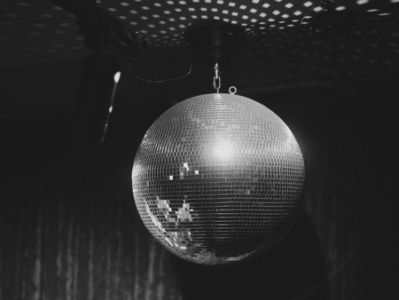 A Beautiful and Shimmering Disco Ball is Hanging Gracefully in an Elegant Black and White Atmosphereの写真素材