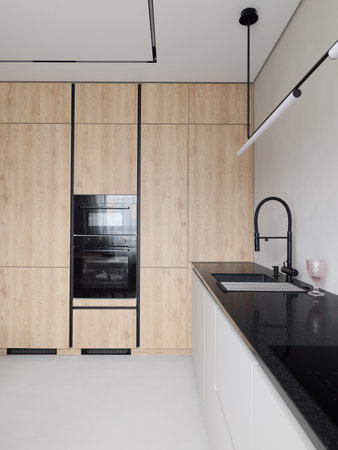 This Modern Kitchen features Stylish Wood and Black Elements that perfectly blend togetherの写真素材