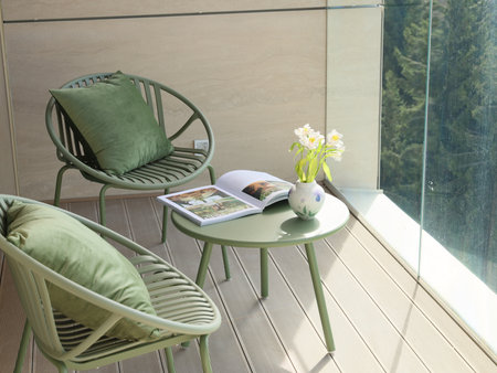 Stylish and Contemporary Green Balcony Seating Complemented by a Beautiful Floral Accentの写真素材