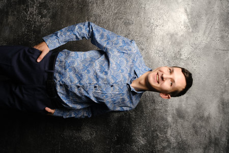 A Confident and Happy Smiling Man Posing Stylishly in a Modern, Trendy Blue Shirtの写真素材