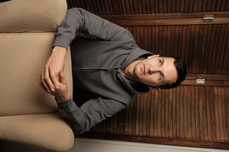 A Contemporary Portrait of a Man Dressed in Casual, Comfortable Attire and Relaxed Posture