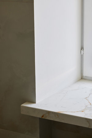 A Minimalist White Corner with a luxurious Marble Surface and smooth wall finishの写真素材