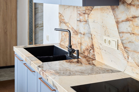 A Stylish Kitchen Featuring Elegant Marble Countertops and a Sleek Modern Faucet Designの写真素材
