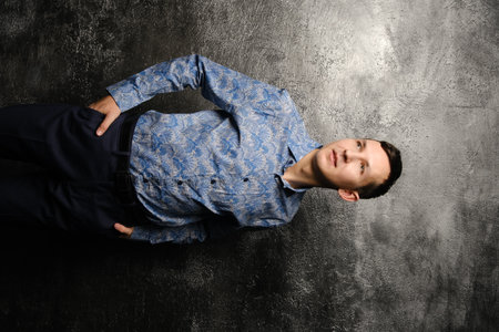A Stylish Young Man Posing Confidently Against a Unique and Textured Background Setting