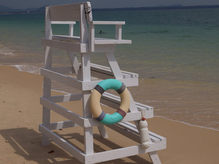 A Lifeguard Chair positioned on a Bright and Sunny Beach, along with a Lifebuoy nearbyの写真素材
