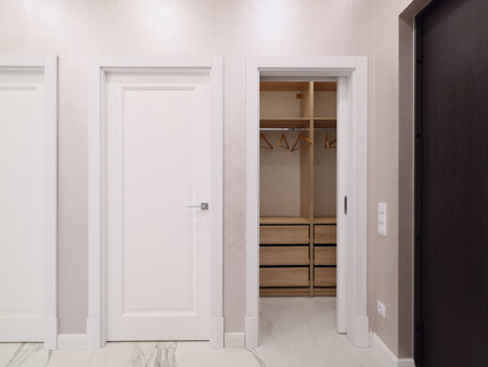 A Modern Interior Featuring an Elegant Closet Design Accompanied by Beautiful Doorsの写真素材