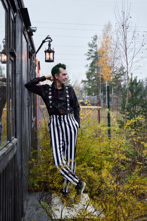 Exploring Dark Fashion with Striped Pants Set Against a Beautiful Autumnal Setting