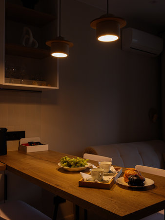 A Cozy Dining Setup Featuring Delicious Food Surrounded by Warm and Inviting Evening Lightingの写真素材