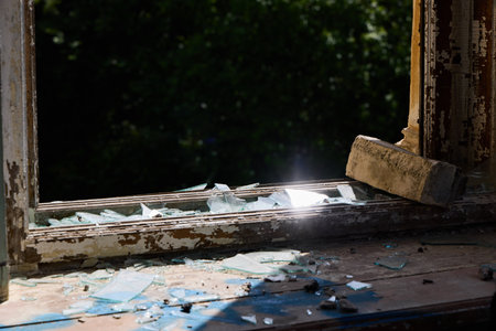 A Sunlit Broken Window that Features Shattered Glass and a Captivating Reflection