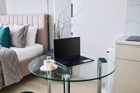 A modern workspace featuring a sleek laptop, set in an inviting and cozy bedroom atmosphereの写真素材