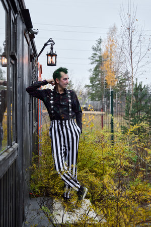 A Fashionable and Stylish Individual Dressed in Striped Pants and Sporting Vibrant Green Hair