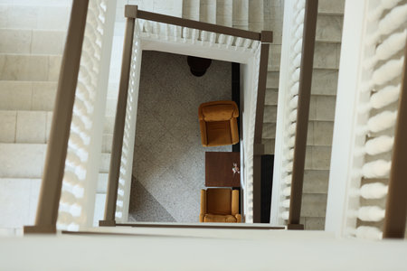 Captivating View from Above A Beautiful Staircase Presenting Chairs and a Tableの写真素材