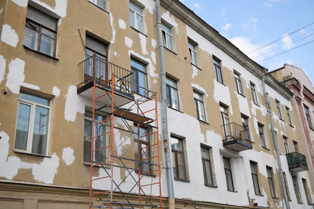 Renovation of a building featuring scaffolding and a paint job that appears unevenly doneの写真素材