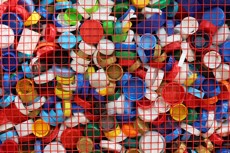 A Vibrant and Colorful Collection of Plastic Bottle Caps Arranged in a Grid Formatの写真素材