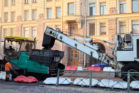 The ongoing road construction in the urban area involves heavy machinery and skilled workers
