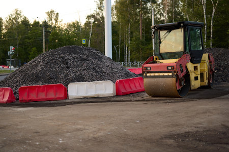 Heavy Machinery at a Construction Site Surrounded by Gravel and Traffic Barriers as Well